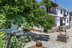 a courtyard of a house with a tree at Fotini Rooms in Skopelos Town