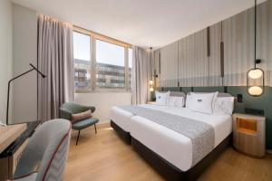 a hotel room with a large bed and a tv at Hotel & Spa Villa Olimpica Suites in Barcelona