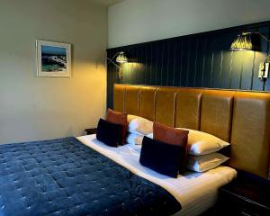 a bedroom with a large bed with two pillows at Lochside Hotel in Bowmore