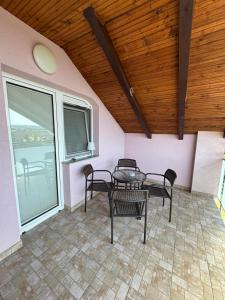 a room with a table and chairs on a patio at Slavuj in Novi Sad +2 photos
