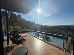 a balcony with a pool and chairs and a view at Loft Vilas Boas in Nova Lima