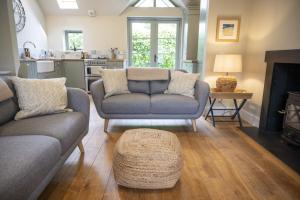 a living room with two couches and a fireplace at Riverside Cottage in Comrie