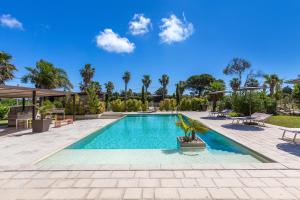 a swimming pool in a yard with palm trees at Agriturismo Li Frutti in Otranto