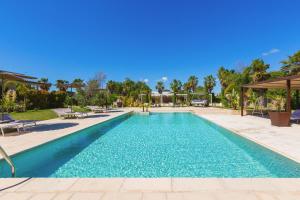 a swimming pool in a villa with palm trees at Agriturismo Li Frutti in Otranto +66 photos