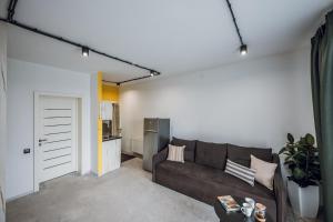 a living room with a brown couch and a kitchen at Aparthotel "Mayak Yablunytsia" in Yablunytsya