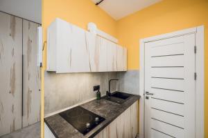 a kitchen with white cabinets and a sink at Aparthotel "Mayak Yablunytsia" in Yablunytsya +26 photos