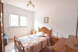 a bedroom with a bed and a dresser and a window at Casa Emiliano in Cee