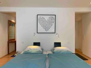 a bedroom with two beds and a heart picture on the wall at Wohnhaus am Marktplatz in Röhrnbach in Röhrnbach