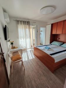 a bedroom with a bed and a desk and a television at Guest House Krk Town Centre in Krk
