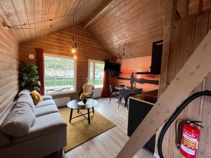 a living room with a couch and a table at Manndalen Sjøbuer in Samuelsberg