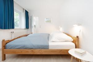 a bedroom with a bed with blue curtains and a table at Gut Staberhof Staberpark in Staberdorf