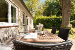 a wooden table and chairs on a patio at Gut Staberhof Staberpark in Staberdorf