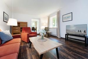 a living room with a couch and a table at Gut Staberhof Staberpark in Staberdorf +25 photos