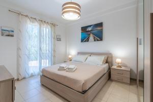 a bedroom with a bed and a large window at La Casa Di Chloe in Marzamemi