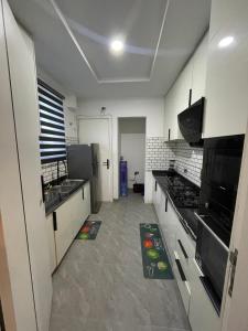a large kitchen with white cabinets and appliances at Precious home apartment II in Lekki