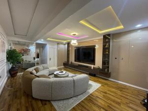 a large living room with a couch and a tv at Precious home apartment II in Lekki