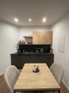 a kitchen with a wooden table and chairs and a kitchen with a counter at Apartmenthaus Zeuthen 3 in Zeuthen