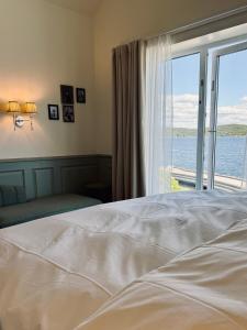 a bedroom with a bed with a view of the ocean at Vilma Sjøbad in Filtvet