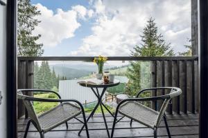 a patio with two chairs and a table on a deck at Aparthotel "Mayak Yablunytsia" in Yablunytsya