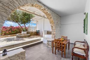 a patio with an archway and a table and chairs at Salty Wind Antiparos Apartments and Studios in Agios Georgios