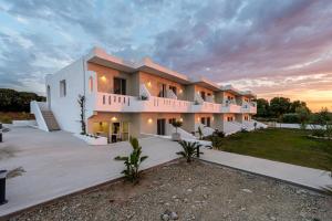 a large building with a sunset in the background at SolMare Premium Suites in Mastihari