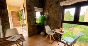 a room with a table and chairs and a stone wall at La Posada de las Flores in Astorga