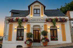 a white house with flowerpots in front of it at La Posada de las Flores in Astorga