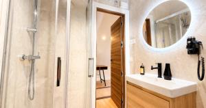 a bathroom with a sink and a shower with a mirror at La Posada de las Flores in Astorga