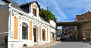a building on the side of a street with a bridge at La Posada de las Flores in Astorga +11 photos
