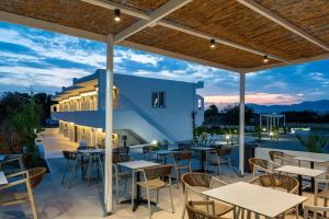 a restaurant with tables and chairs on a patio at SolMare Premium Suites in Mastihari
