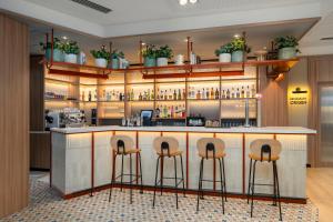 a bar with three stools in a room at Hotel & Spa Villa Olimpica Suites in Barcelona +16 photos