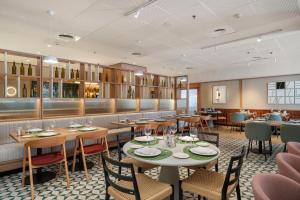 a restaurant with tables and chairs and a bar at Hotel & Spa Villa Olimpica Suites in Barcelona