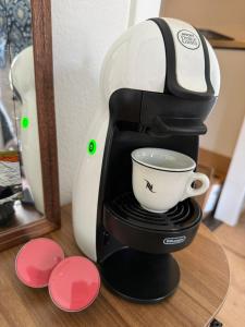a coffee maker sitting on a table with a cup at Studio chic et élégant avec Wi-Fi et Smart TV in Lausanne