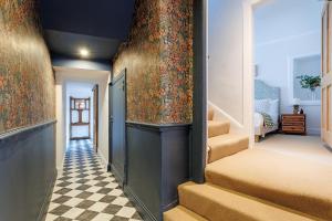 a hallway with stairs and a wall with floral wallpaper at The Greenhouse Ayr in Ayr