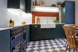 a kitchen with blue cabinets and a sink and a stove at The Greenhouse Ayr in Ayr