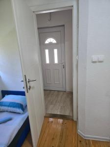 a door leading to a room with a bed and a window at Papillon in Visoko