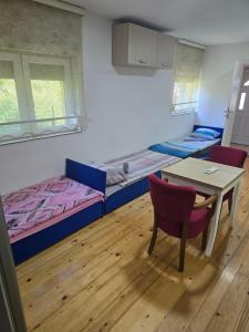 a room with two beds and a table and chairs at Papillon in Visoko +1 photo