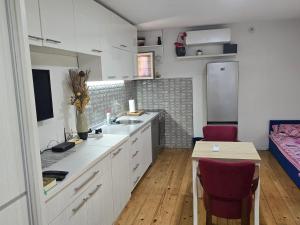 a kitchen with a sink and a table in a room at Papillon in Visoko
