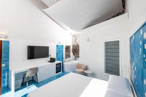 a bedroom with a bed and a tv on a wall at Le Suite dei Pescatori in Praiano