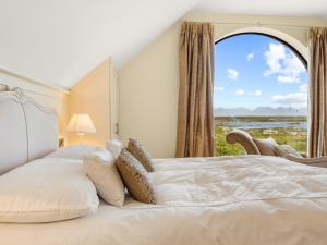 a bedroom with a bed with a large window at Calla Lookout in Roundstone