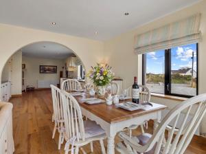 a dining room with a white table and chairs at Calla Lookout in Roundstone