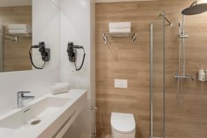 a bathroom with a shower and a toilet and a sink at B&B HOTEL Covilhã in Covilhã +11 photos