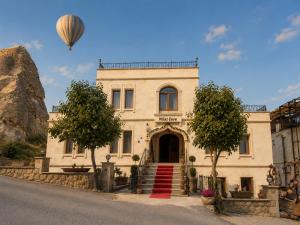 a hot air balloon flying over a building at Milat Cave in Göreme
