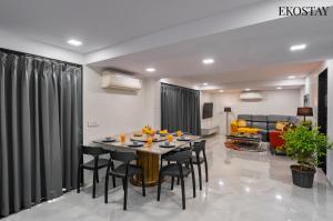 a dining room and living room with a table and chairs at EKOSTAY - ONYX Villa in Mumbai