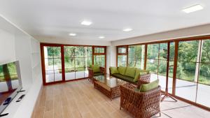 a living room with a couch and chairs and windows at Relocation Dili House in Dilijan