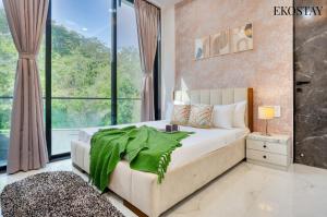 a bedroom with a large bed and a large window at EKOSTAY - ONYX Villa in Mumbai