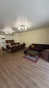 a living room with a couch and tables and chairs at Relocation Dili House in Dilijan
