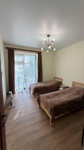 a hotel room with two beds and a window at Relocation Dili House in Dilijan