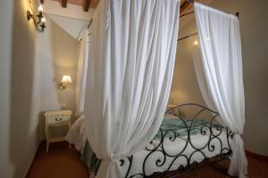 a bedroom with a bed with white curtains at Tenuta Piroddi in Montemurlo