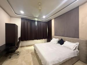 a bedroom with a bed and a chair and a window at Hotel Pratap Palace in Bharatpur